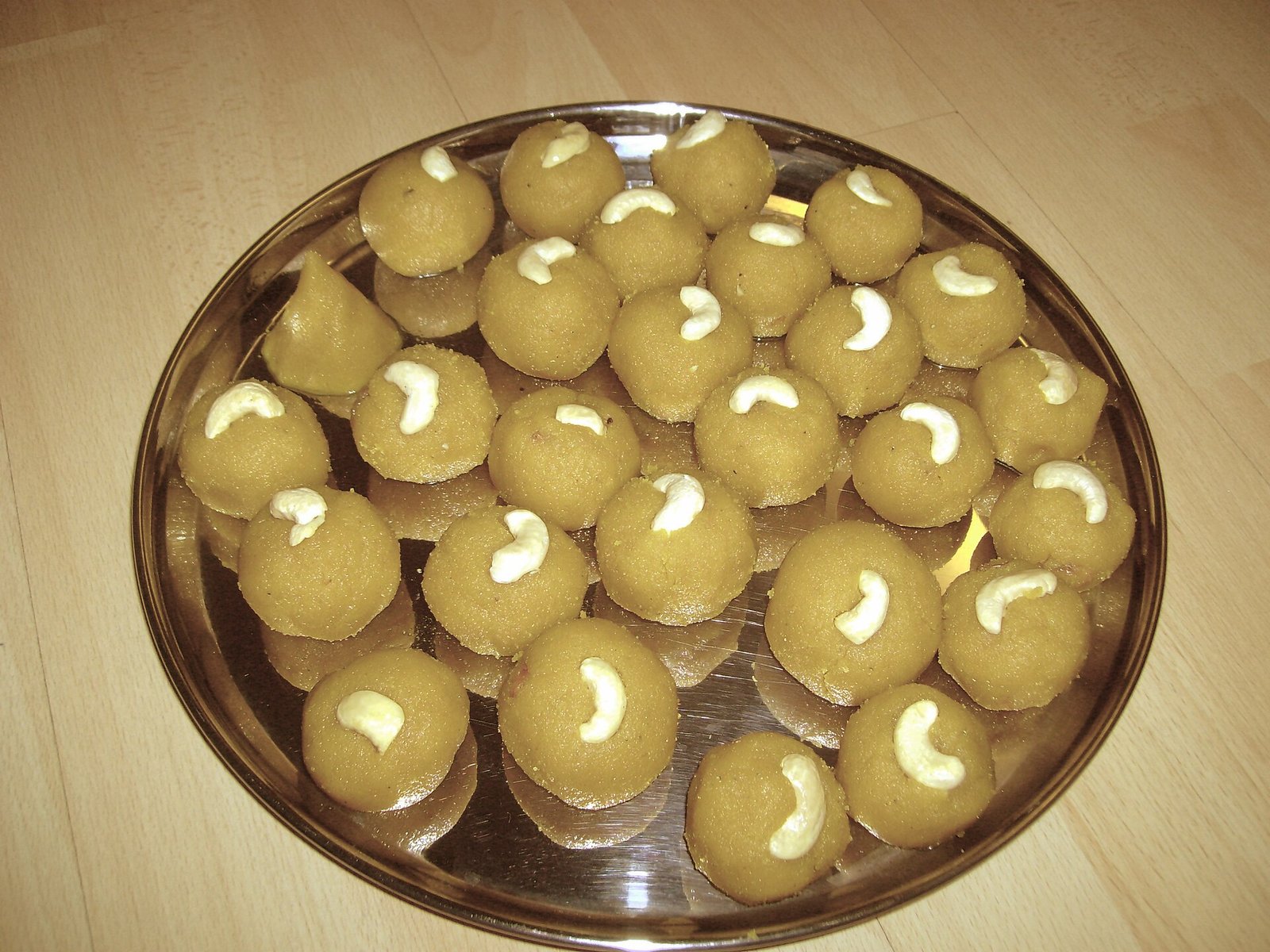 Round golden besan ladu arranged on a plate