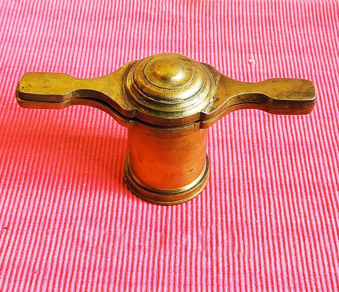 A traditional brass chakli press (soryacha sancha) with its discs laid out beside it