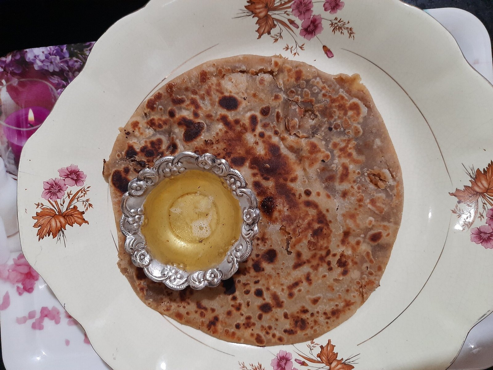 Puranpoli on a plate with a spoonful of melting ghee